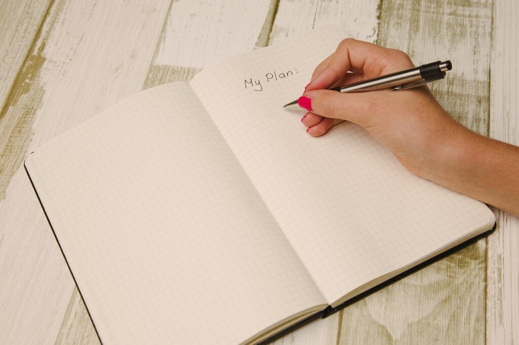 A person writing in a notebook about the getting things done method.